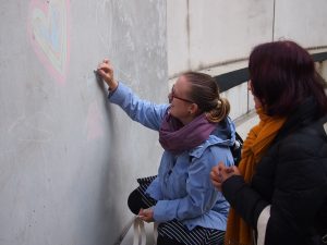 Illustrationsbild: Två kvinnor som ritar på en vägg med gatukritor.