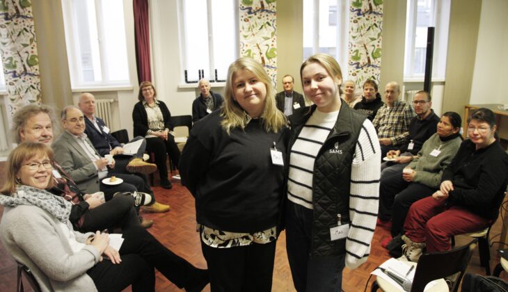 Diskussionsledarna Marica och Maj står i förgrunden med deltagarna i dialogcaféet i Borgå i bakgrunden.