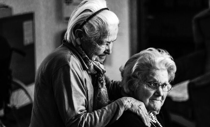 Två äldre damer som hjälper varandra.