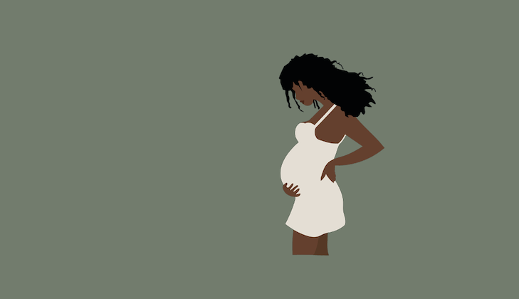 Gravid kvinna med handen på magen.