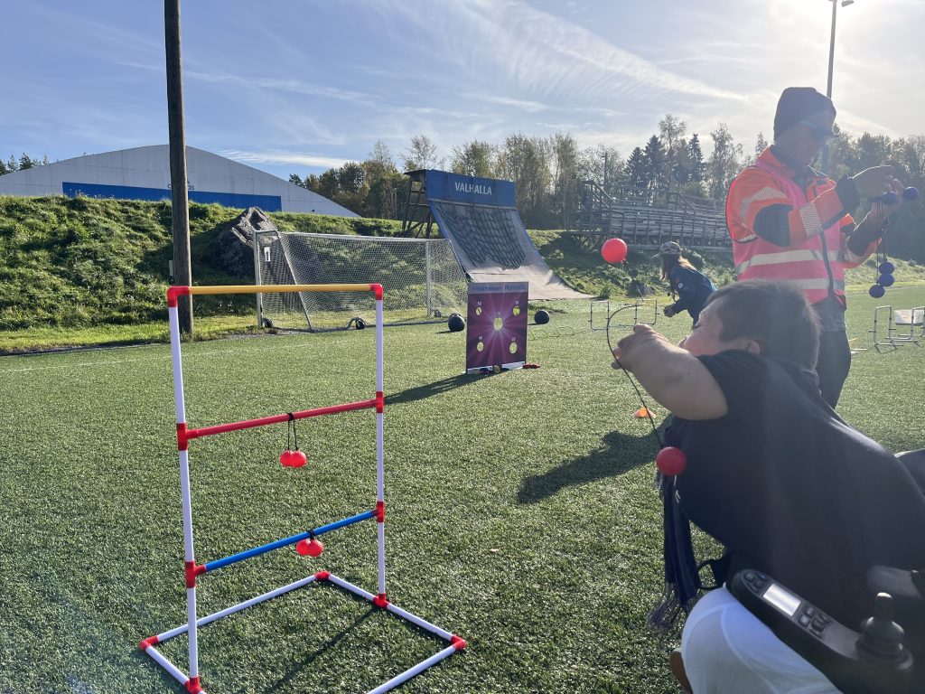 En person kastar en boll mot en steggolfställning.